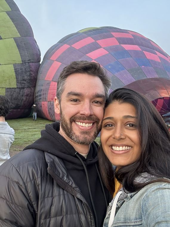 Smiling in front of hot air balloons before the flight