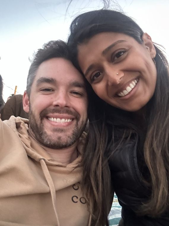 Pooja and Derrick cheek to cheek in warm golden-hour light