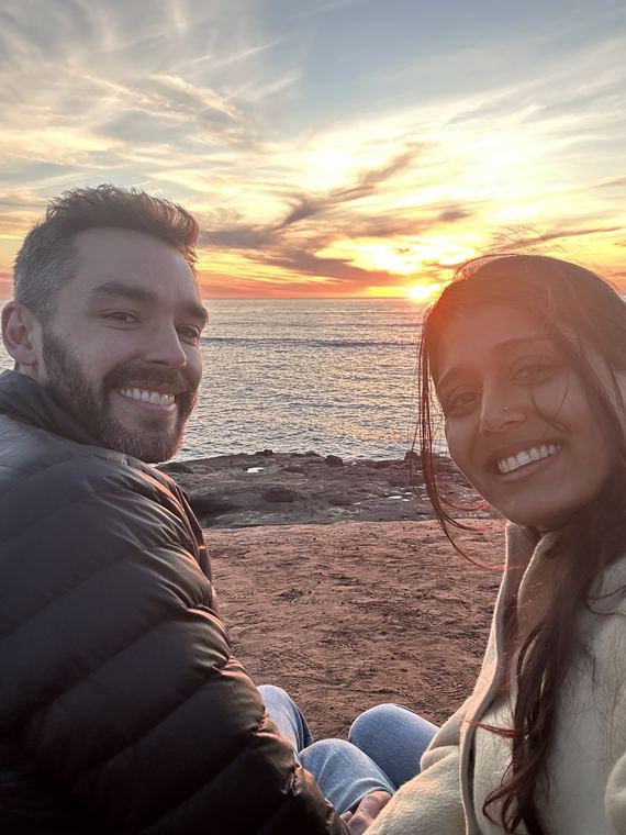 Selfie on the beach as the sun sets behind them