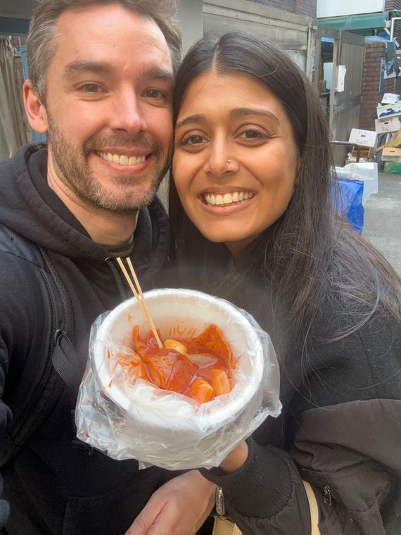 Sharing tteokbokki at a market in Seoul